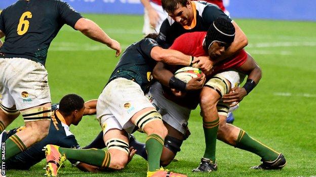 Maro Itoje is tackled by two South Africa players