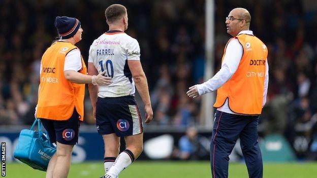 Owen Farrell is led off the pitch by medics