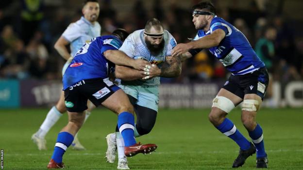 Joe Marler of Harlequins is tackled by Josh Bayliss (R) and D'Arcy Rae