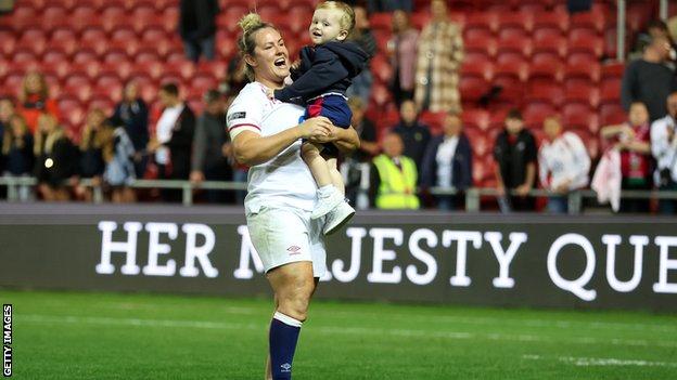 Marlie Packer holding her son Oliver after a game