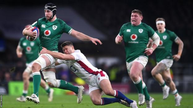 Ireland's Caelan Doris runs with the ball and England's Ben Youngs attempts to tackle him